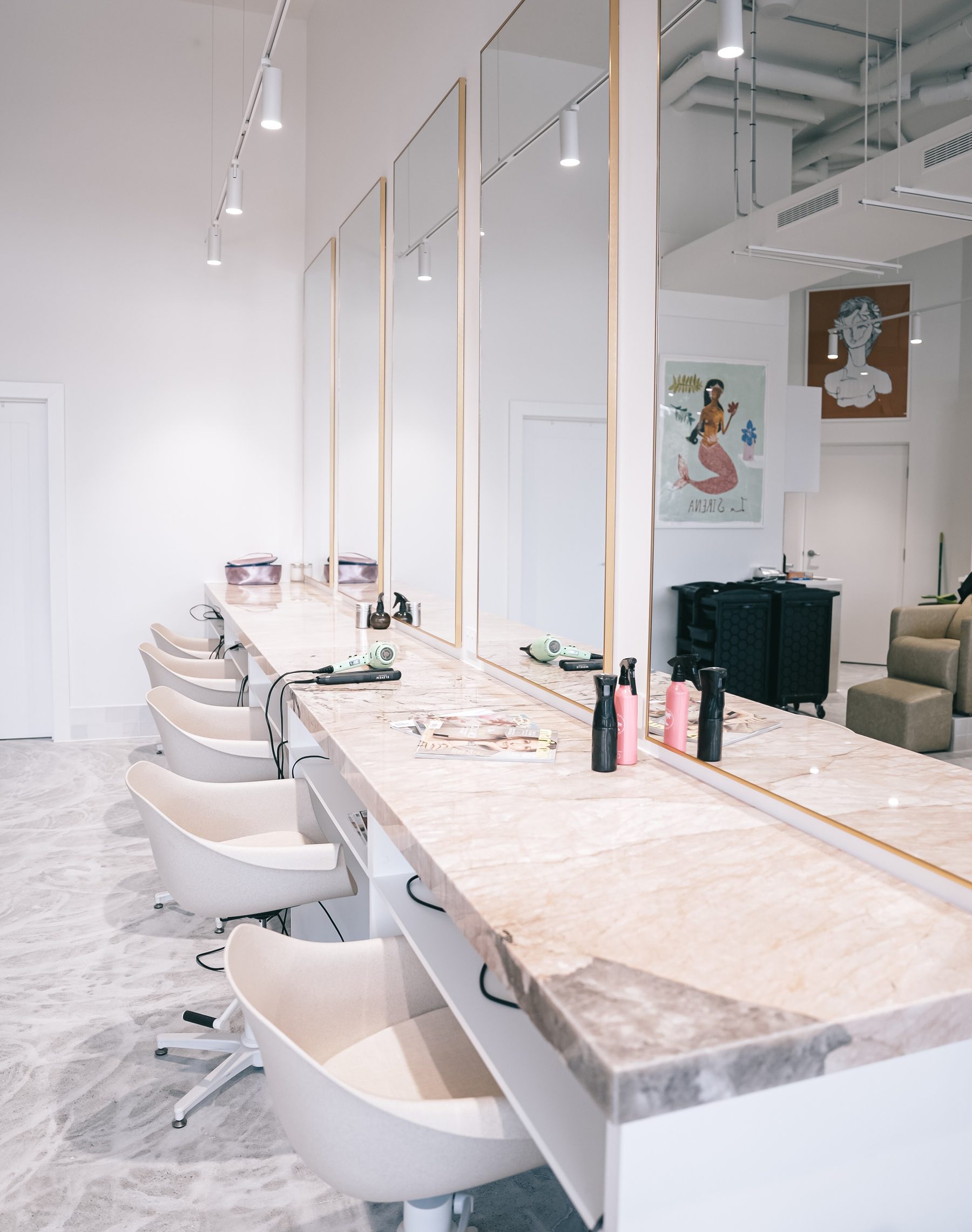 The Elizabeth & Co. styling stations, with marble counters and gold-framed mirrors.